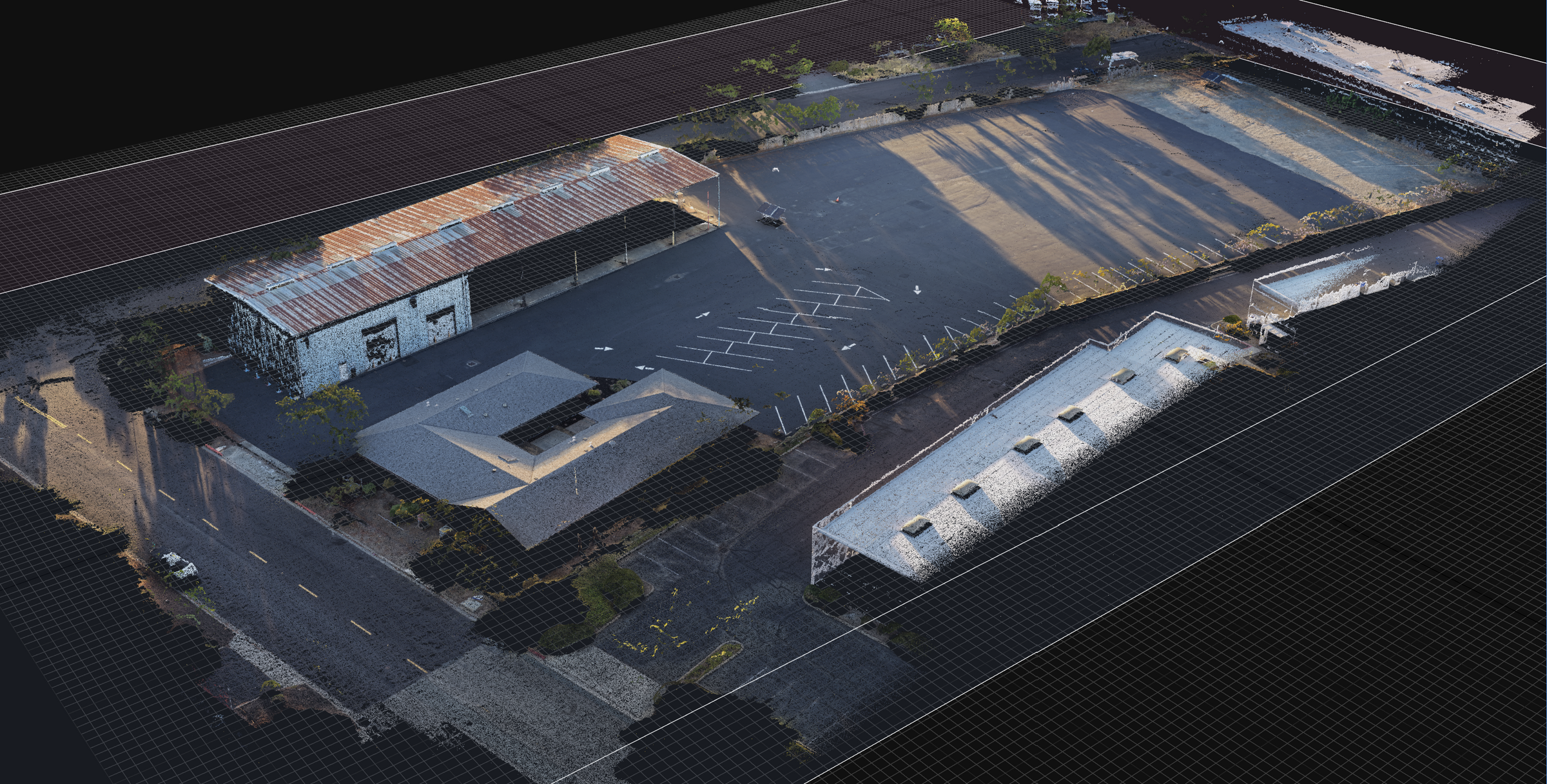Aerial-style 3D render of an industrial lot with multiple warehouses, a large paved parking area, roads, and some vegetation under dramatic low-angle sunlight.